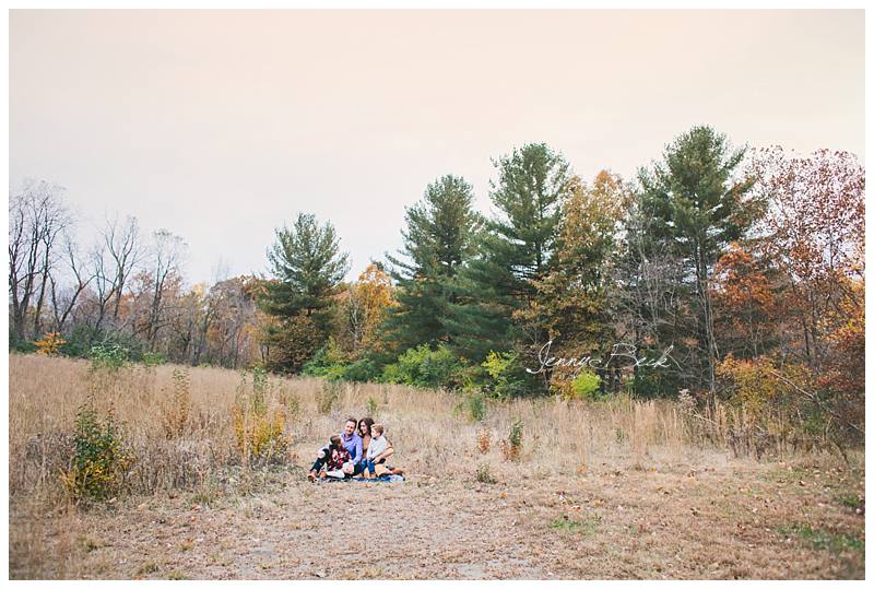 family sitting and looking at each other with scenic background in new albany ohio nature park