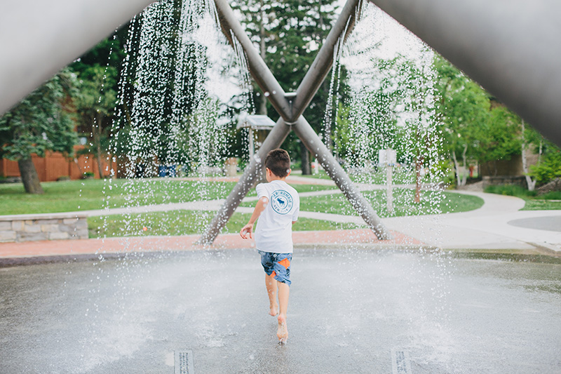 boy running through water play area at clinch park traverse city michigan