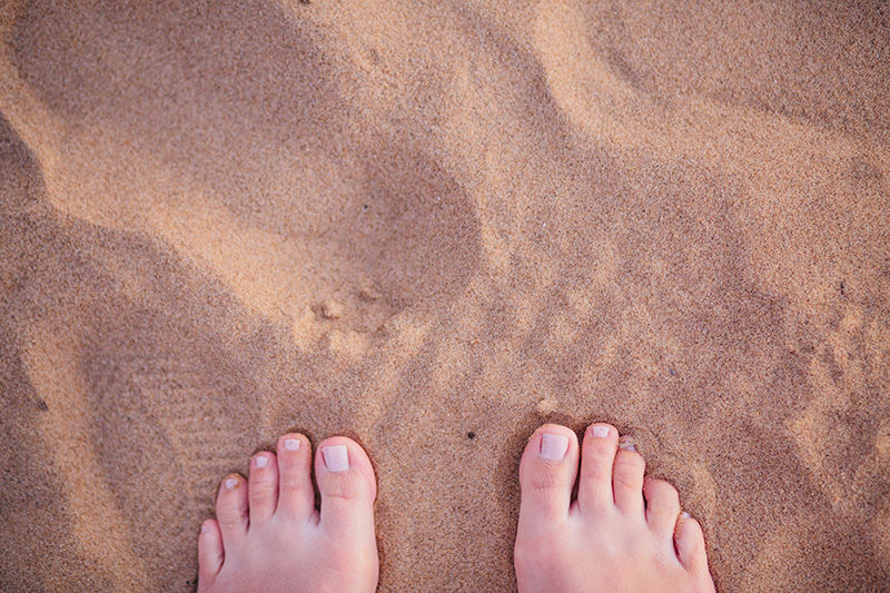 photo of woman's toes in the sand on lake michigan beach
