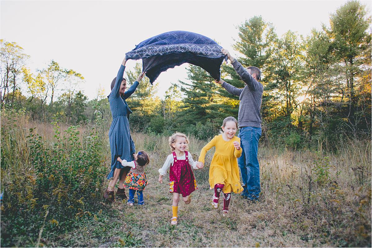 Westerville Ohio family photographer - fun family photos of kids running under arch at sunset in nature park